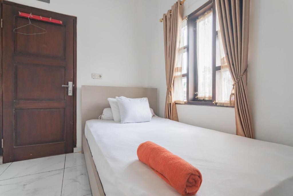 万隆Small Homestay Syariah Sikembar Ciwidey Mitra RedDoorz的一间卧室配有一张带橙色毛巾的床