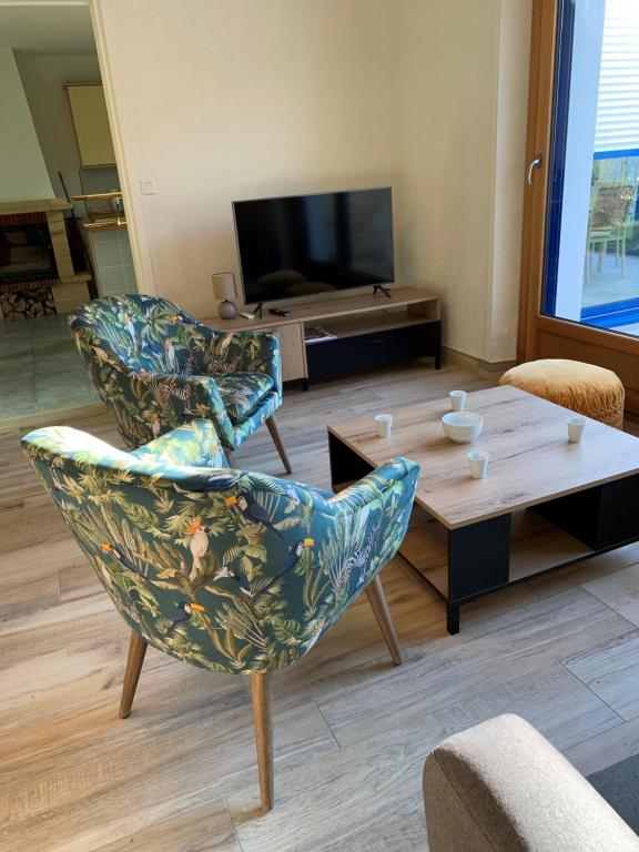 吉代勒Maison à 800 m à pied de la plage的客厅配有两把椅子和一张茶几