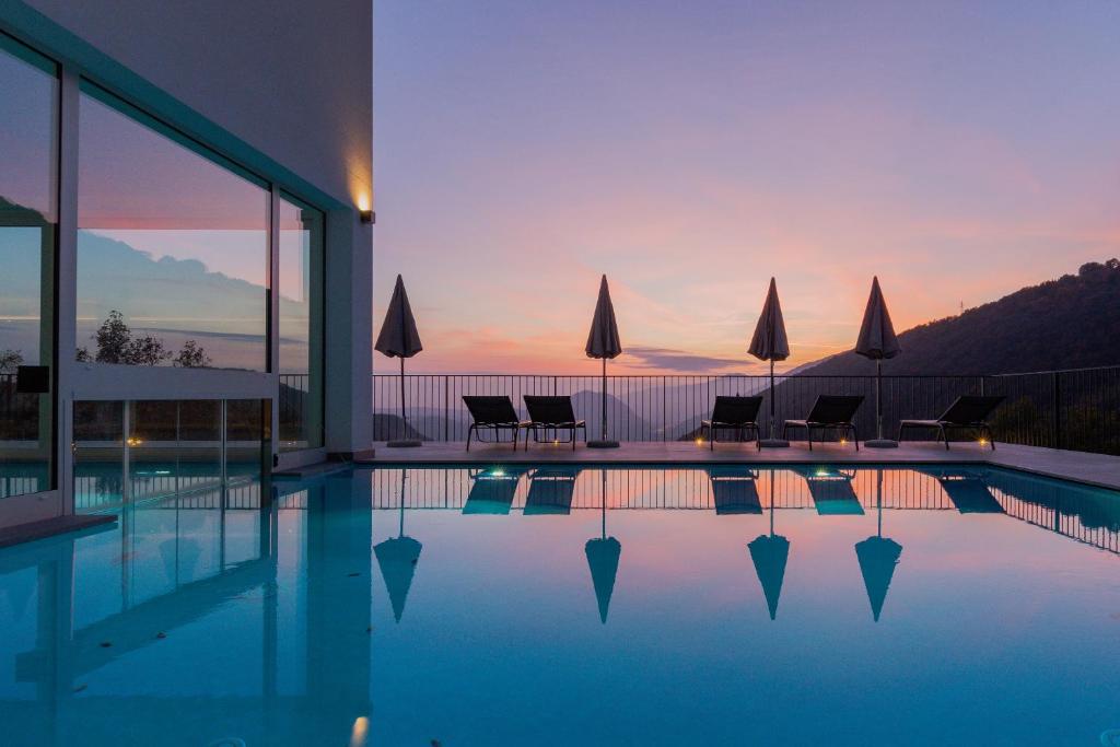 萨罗Il Bagnolo Eco Lodge的一个带椅子的游泳池,享有日落美景