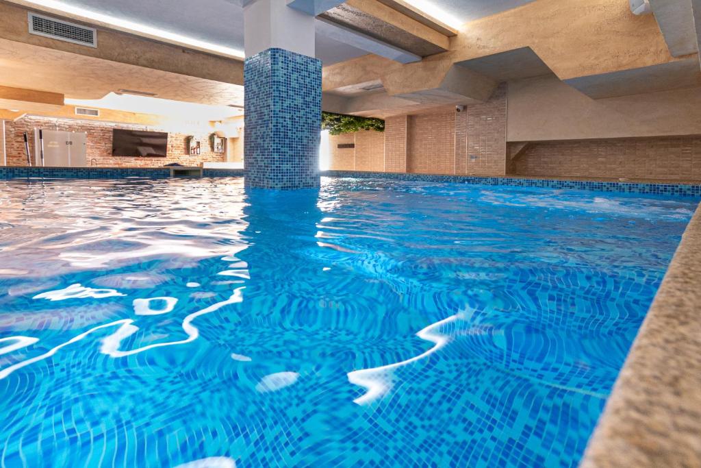 巴尼亚Баня Аква Ризорт的蓝色水中的酒店的游泳池