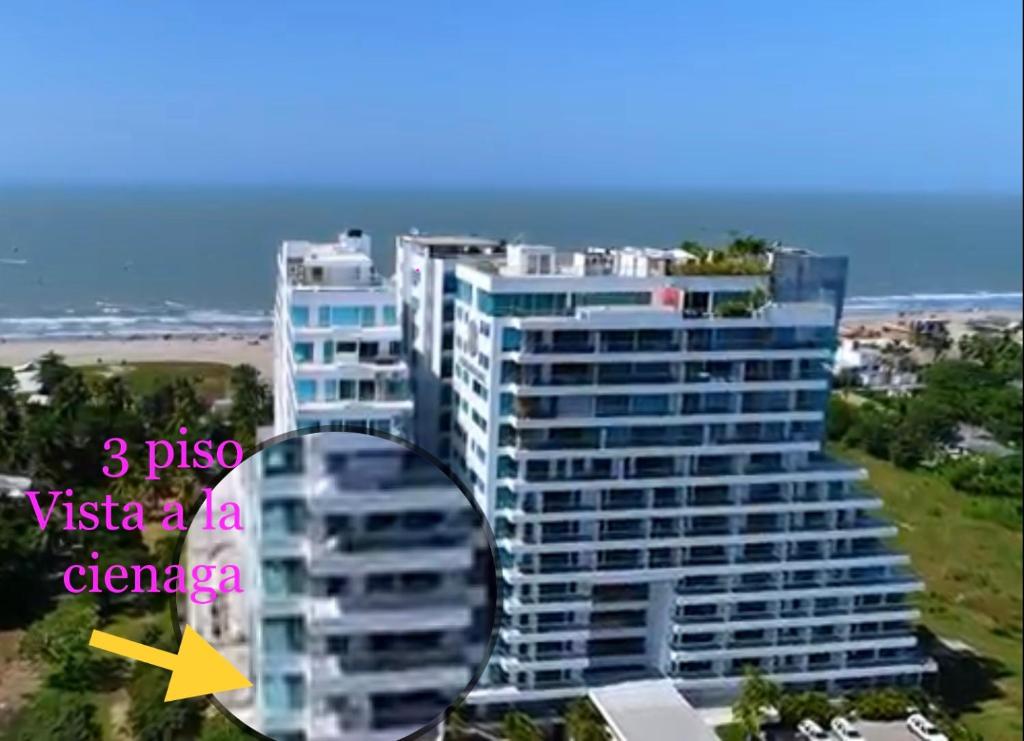 卡塔赫纳Playa la Boquilla, Apto dentro Condominio Hotel Sonesta的一座高大的公寓楼,上面有黄色的箭头