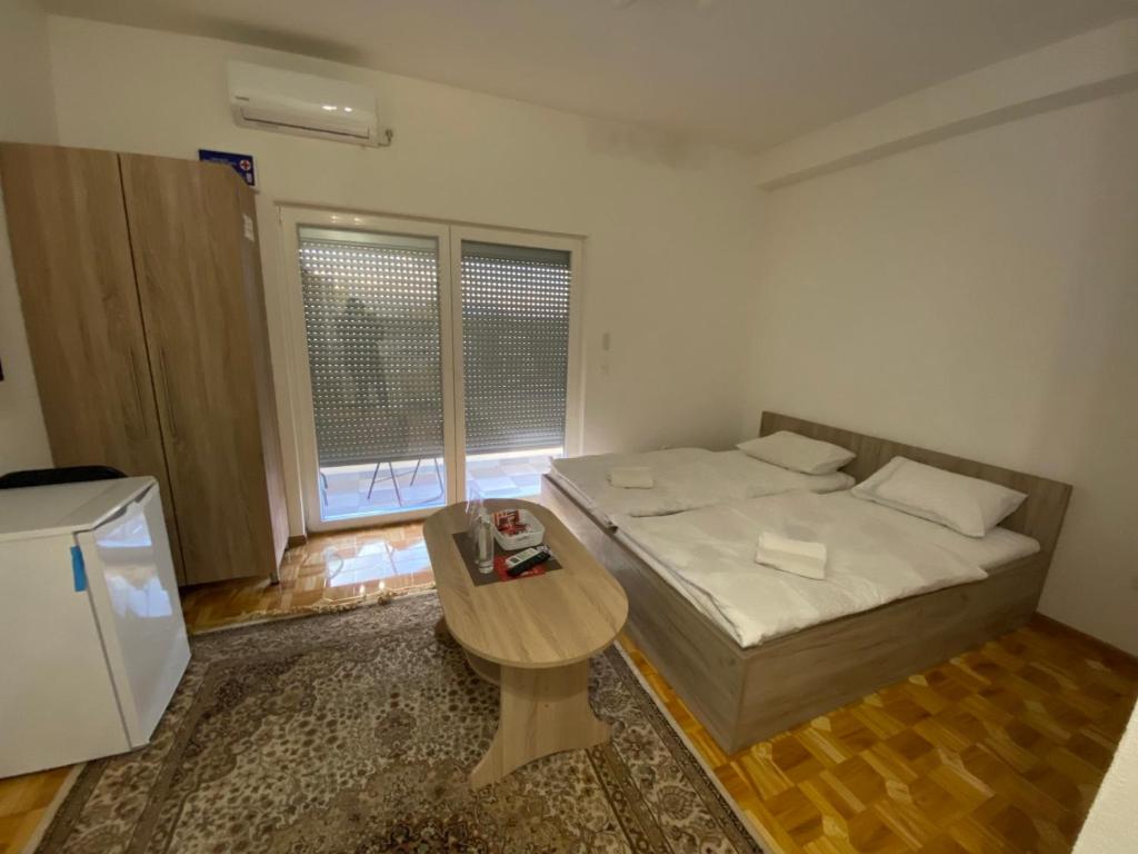ŽiviniceApartmani Hadžić的小房间设有一张床和一张桌子