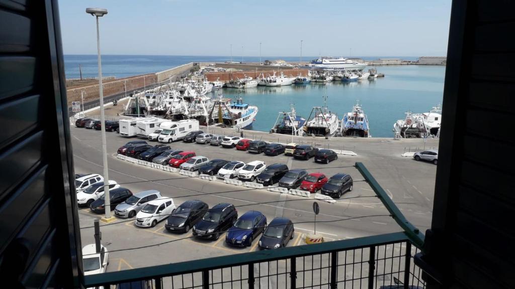 泰尔莫利La dimora sul porto的享有码头的景色,停车场有车辆停放