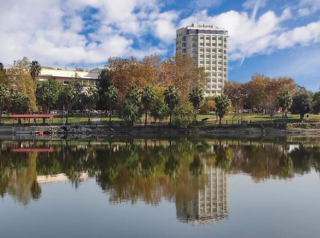 阿达纳Türkmen Riverside Hotel Adana的湖畔高楼,有建筑