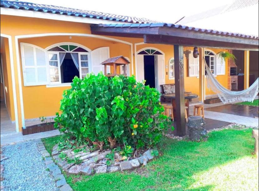 弗洛里亚诺波利斯Ótima Casa para 10 pessoas /menos de 100m da Praia的黄色房子前面设有吊床