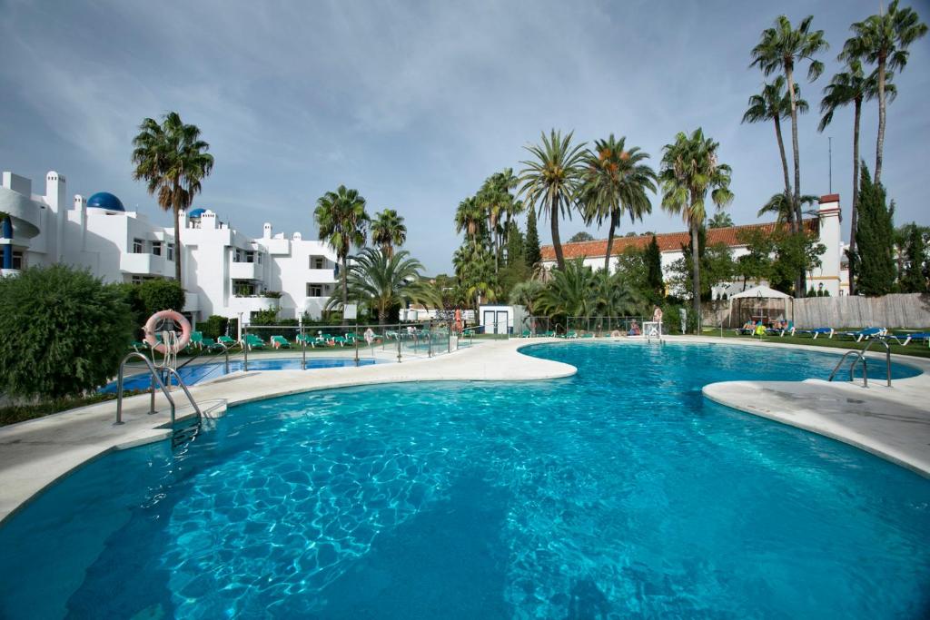 卡拉德米哈斯奥纳康帕纳里欧公寓式酒店的一座棕榈树和建筑的大型游泳池