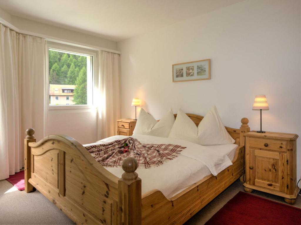 圣莫里茨圣莫里茨彻萨弗洛拉公寓的一间卧室设有一张木床和一个窗户。