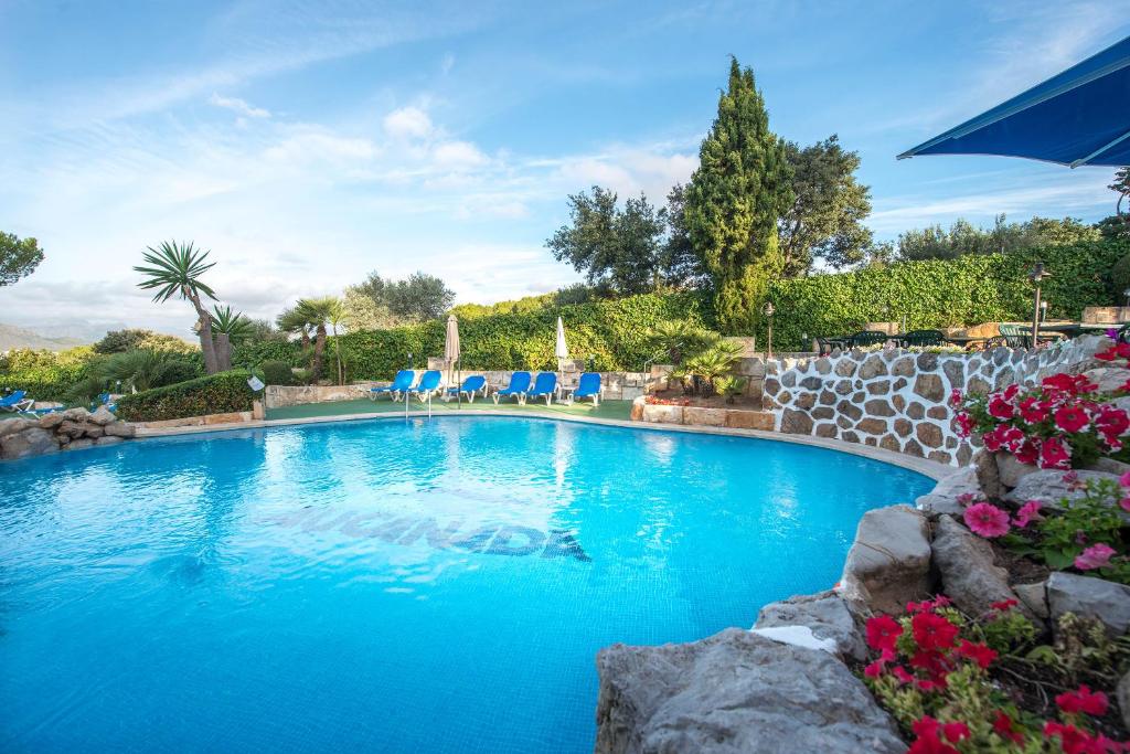 阿尔库迪亚港欧纳奥坎纳达公寓式酒店的庭院内带蓝色椅子的大型游泳池