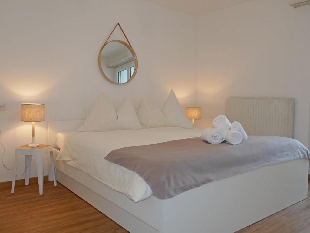 圣莫里茨欧瓦考茨纳12/14公寓的卧室配有一张带镜子的白色大床