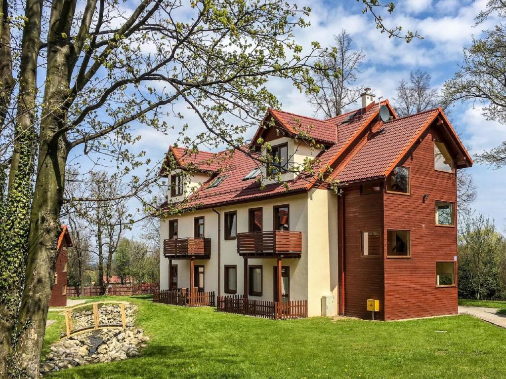 卡尔帕奇Apartment Nad Łomniczką-3 by Interhome的绿色庭院中一座红色屋顶的房子