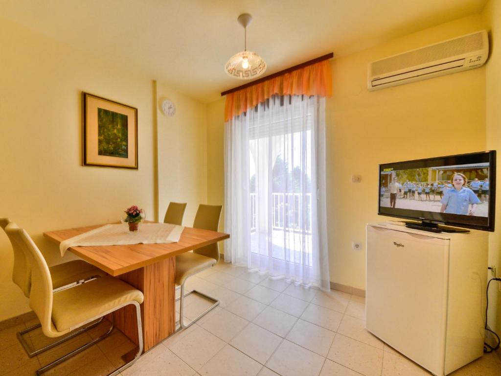 拉布Apartment Fani-1 by Interhome的客厅设有餐桌和电视