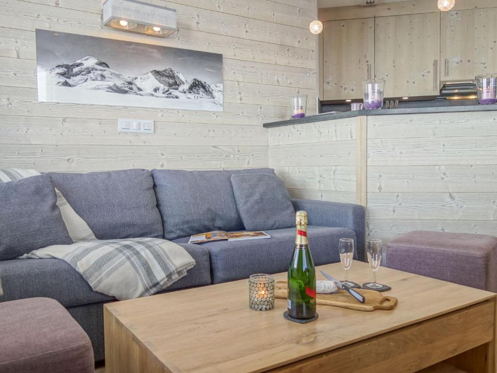 蒂涅Apartment Le Curling B - Val Claret-35 by Interhome的客厅配有沙发和1瓶餐桌葡萄酒