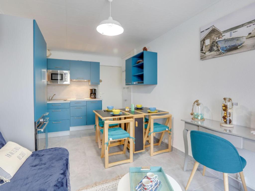 朋泰雷克Apartment Les Jardins de l'Océan-41 by Interhome的厨房配有蓝色橱柜和桌椅