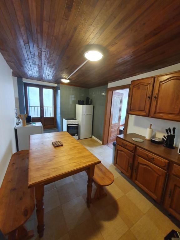 米尔库尔Gite des luthiers的厨房设有木桌和木制天花板。