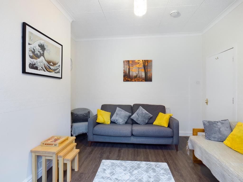 切斯特Cheerful 3 bedroom home with free parking and WIFI的客厅配有蓝色的沙发和黄色的枕头。