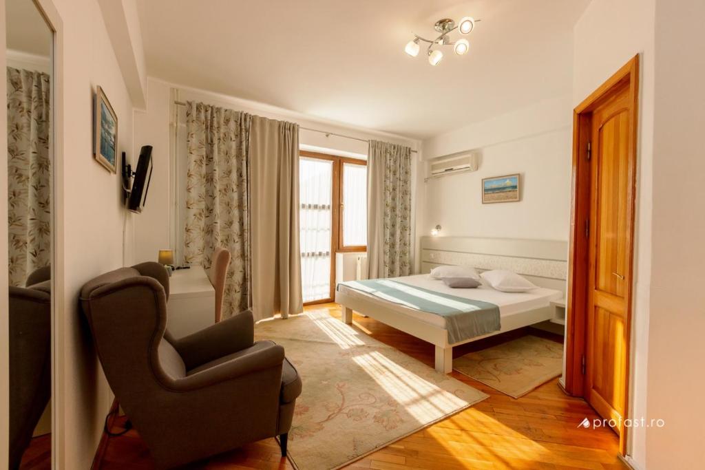 加拉茨Vila Belvedere的一间卧室配有一张床和一把椅子
