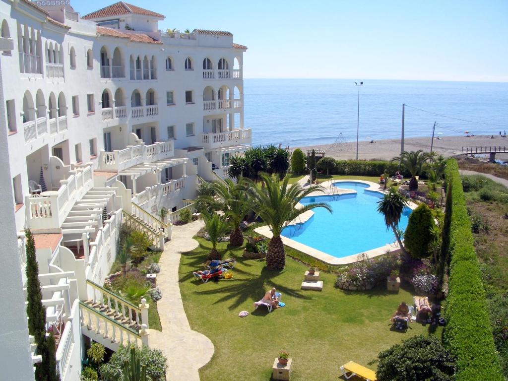 内尔哈Apartamentos StarNerja en Stella Maris的享有度假胜地的空中景致,设有游泳池和海洋