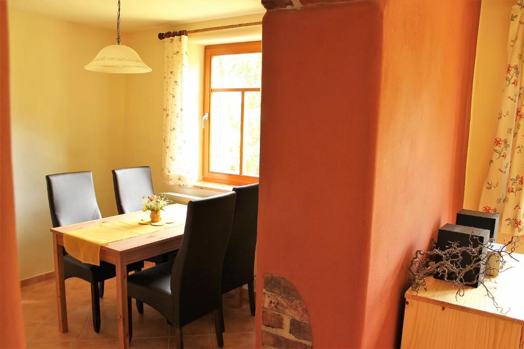 施莱茨Pension 'Am Vogelherd'的一间带桌椅和窗户的用餐室