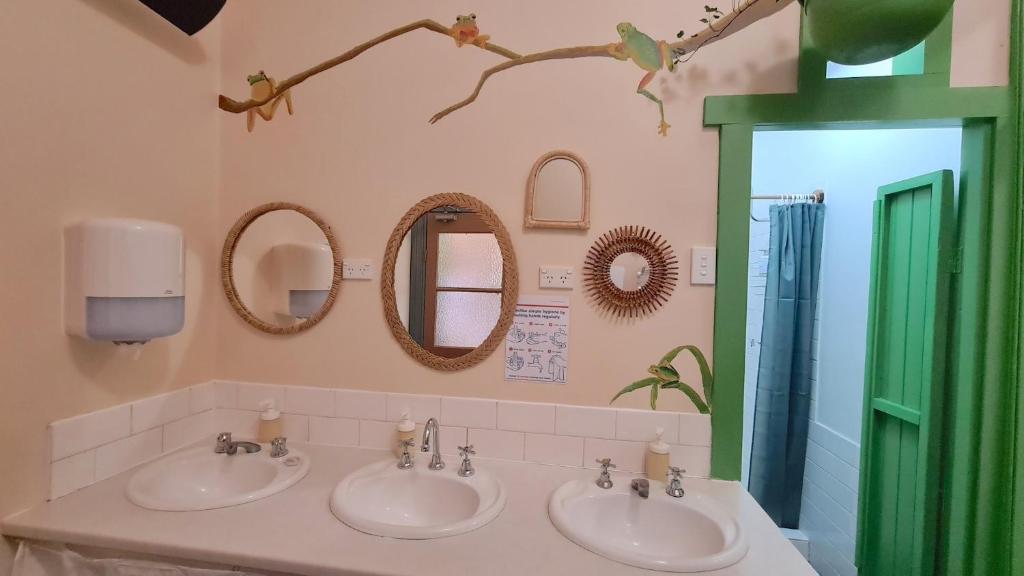 肯图巴No14 Lovel St的一间带三个水槽和镜子的浴室以及一扇绿门