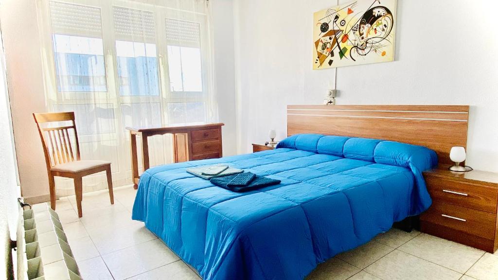 莱昂叟尔纳森特旅馆的一间卧室配有蓝色的床和椅子