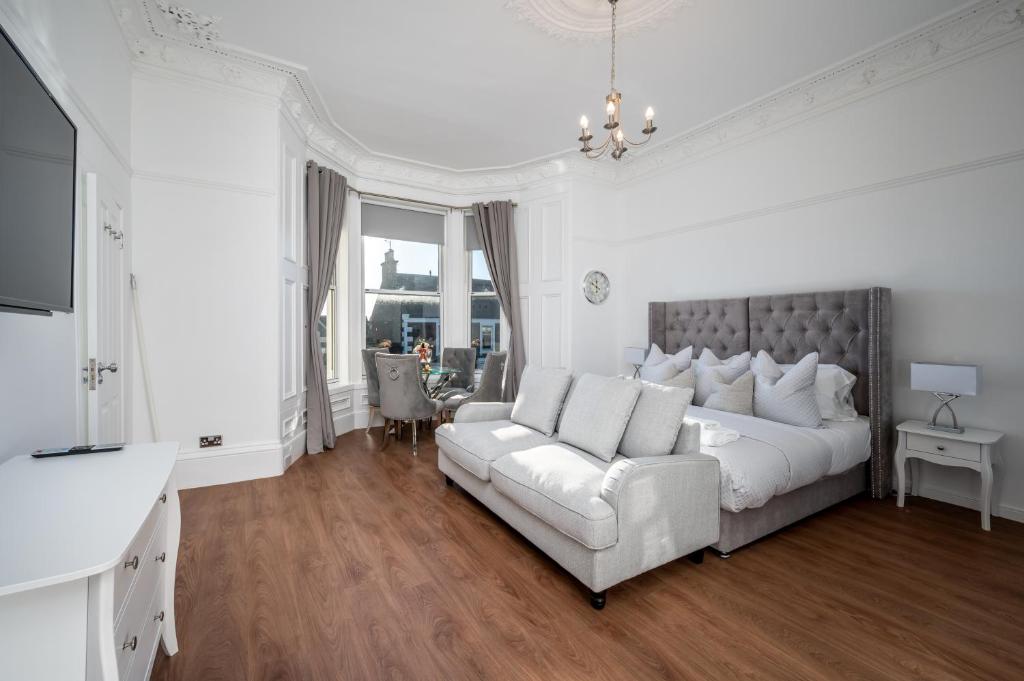 布罗迪菲利Casa Fresa - Orchar Suites的白色卧室设有一张大床和一张沙发