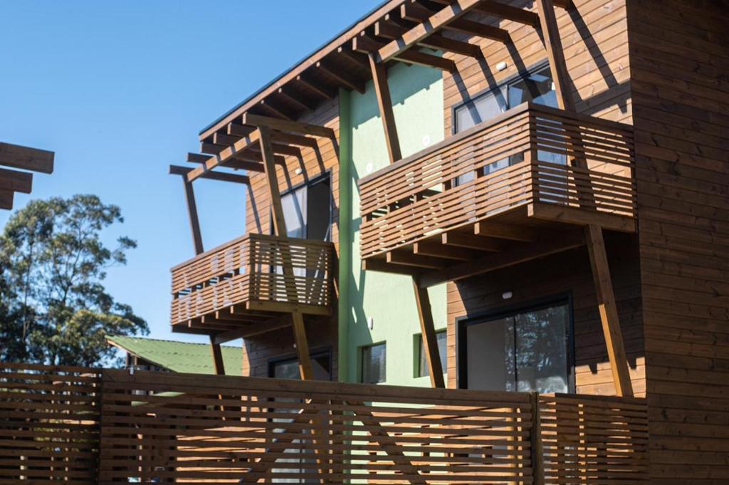 因比图巴Local da Lagoa Chalés e Lofts的房屋的一侧设有木制阳台