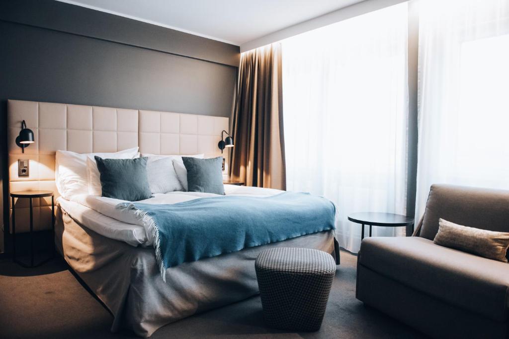 乌普萨拉克拉丽奥吉莱特酒店的一间卧室配有一张床、一张沙发和一把椅子