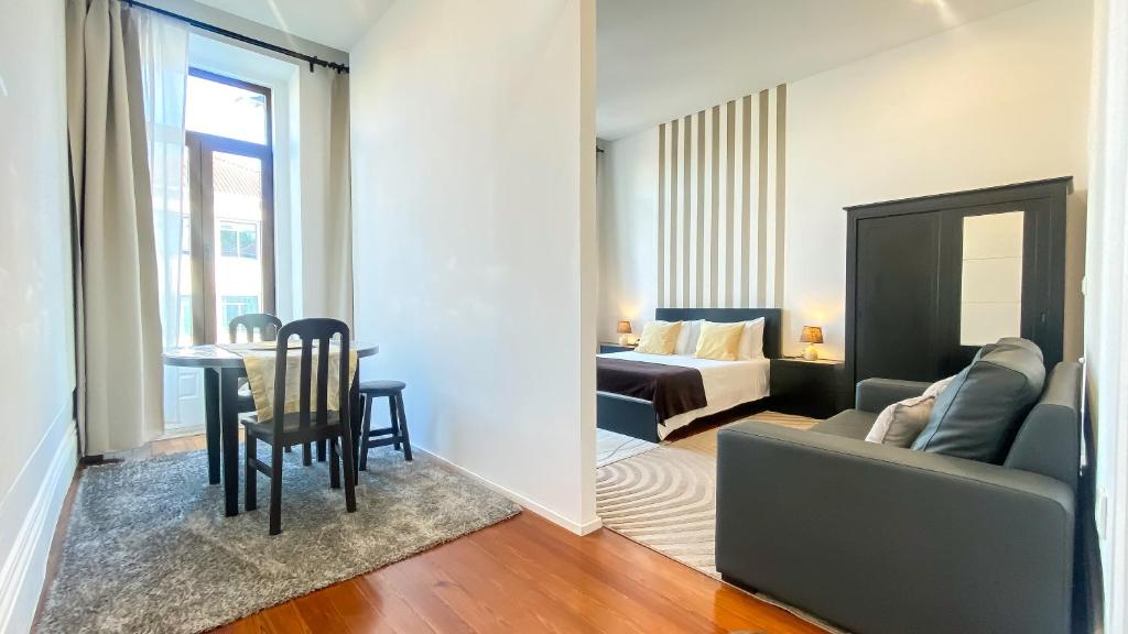 波尔图Gardenia Aparthôtel的客厅配有沙发、桌子和床。