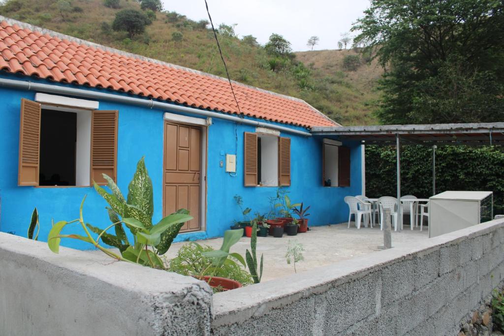 PicosCasa Pé di Polon holiday home的前面有水泥墙的蓝色房子