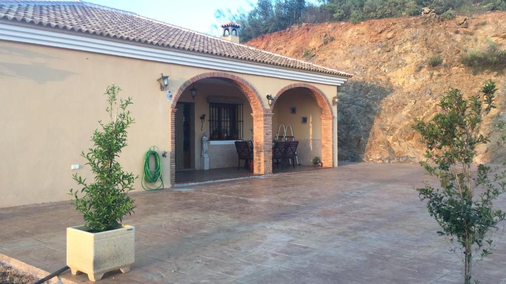 AlmogíaCasa Cuatro Vientos - Barranco Del Sol的一座带庭院和拱门的房子