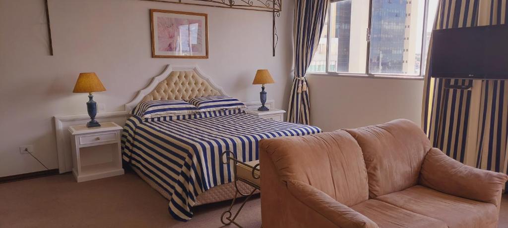大坎普大坎普捷达酒店的配有一张床和一把椅子的酒店客房