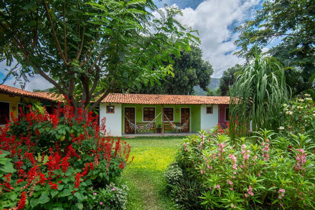 韦尔卡鲍Pousada Aconchego的花园中种满鲜花的房子