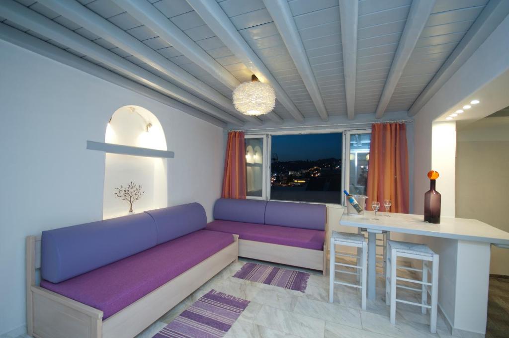 米克诺斯城米科诺斯滨海公寓的客厅配有紫色沙发和桌子