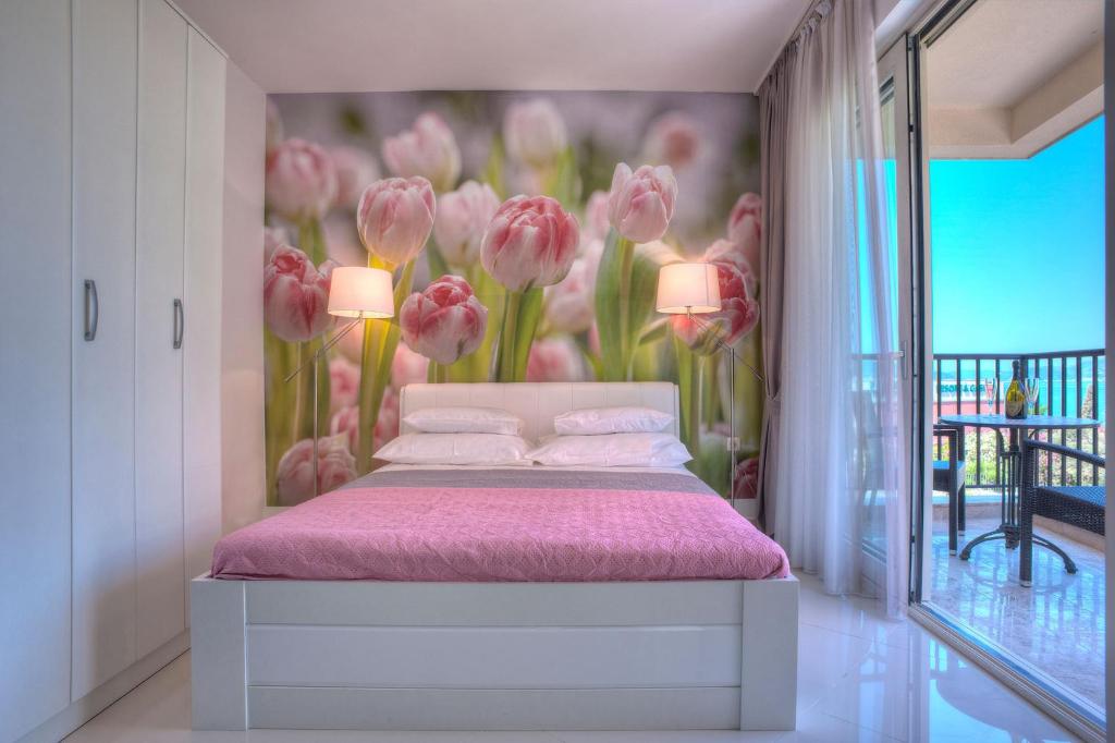 斯韦蒂·斯特凡Guest House Pržno Bay的一间卧室配有一张带粉红色床单和粉红色鲜花的床。