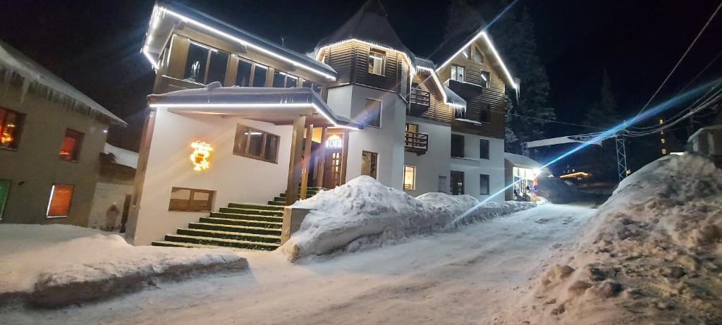 德拉格布拉特U Stozi Hotel的夜晚有雪覆盖的房子