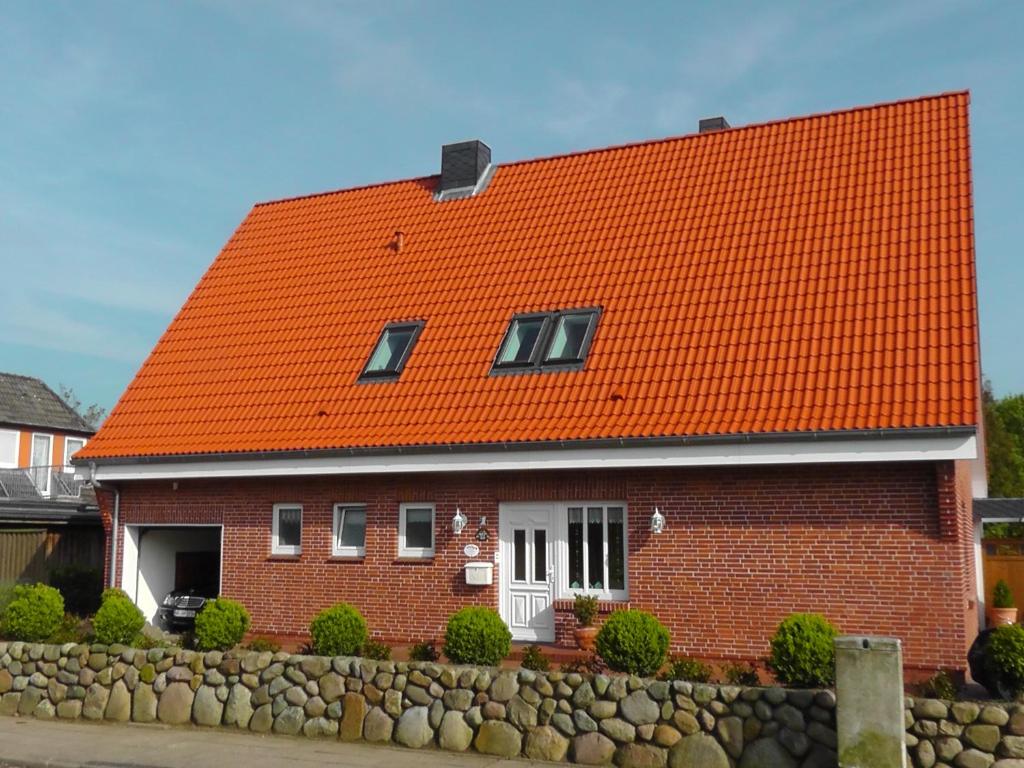 滕宁Haus Wattenmeer的红砖房子,有橙色屋顶