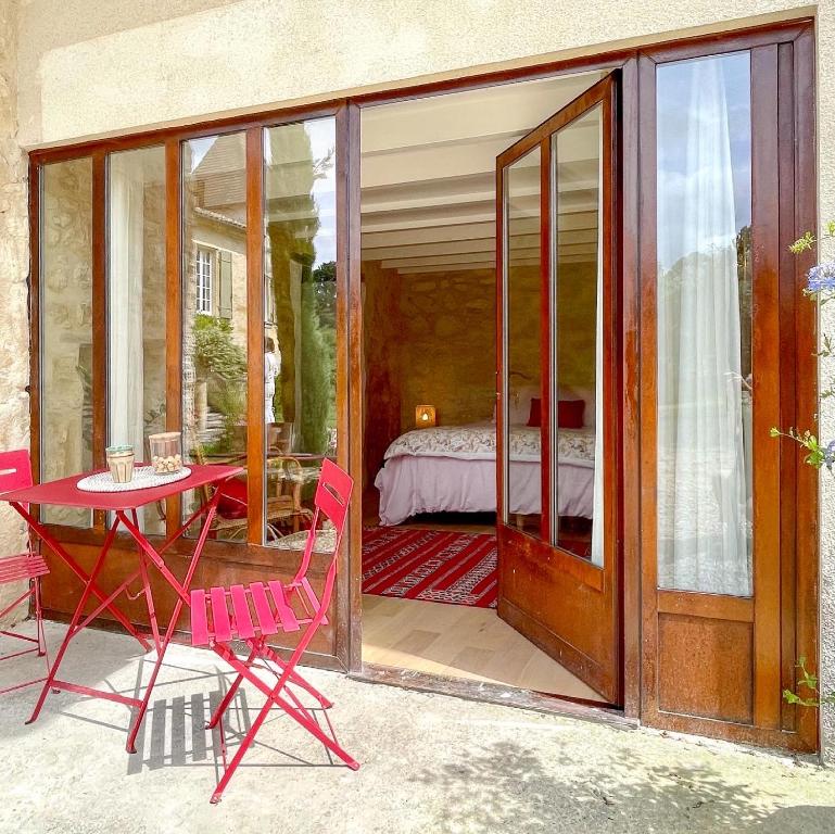 GrézillacLe Tilleul的一个带桌椅的庭院和一间卧室
