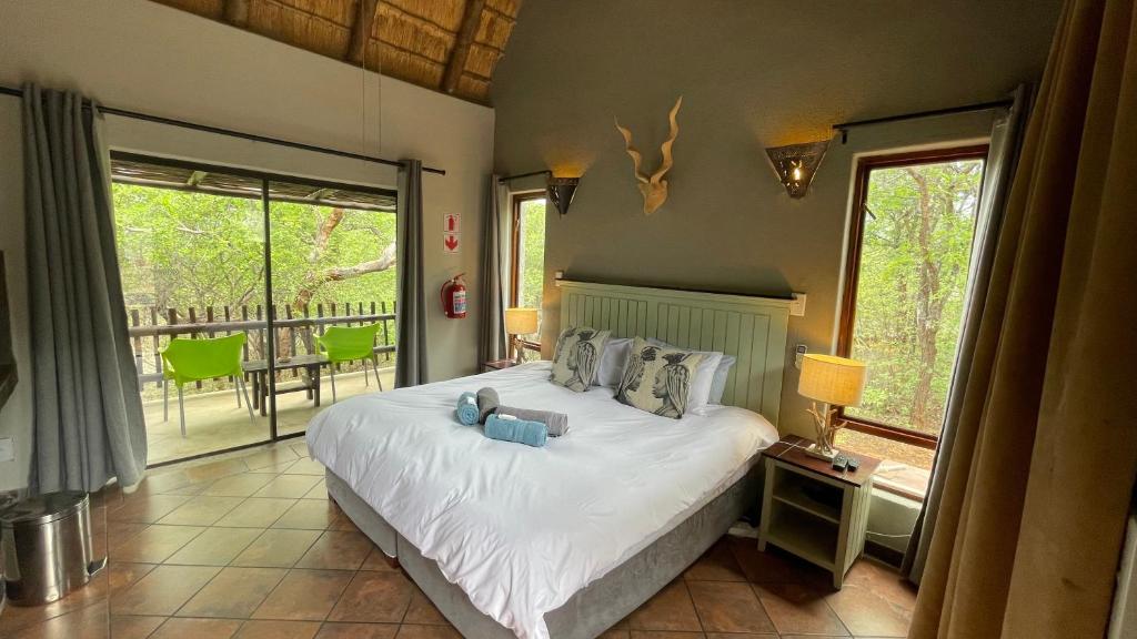 侯斯普瑞特Ujabule Lodge的一间带大床的卧室和一个阳台