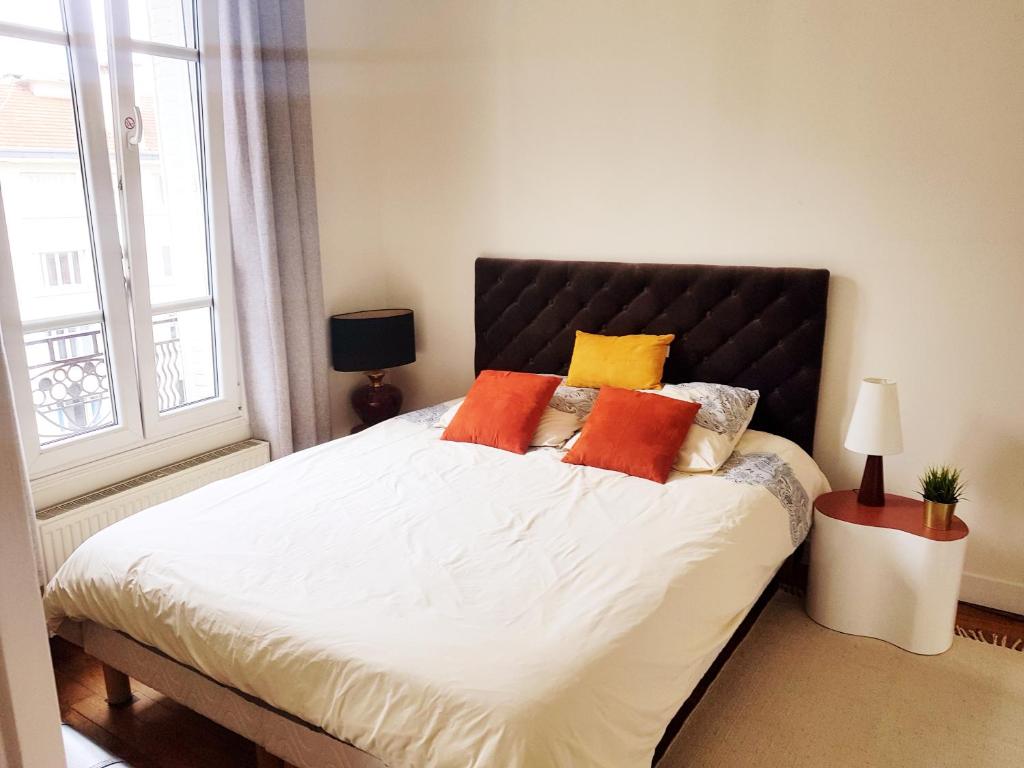 布洛涅-比扬古Anna's Home Sweet Home的一间卧室配有一张带橙色和黄色枕头的大床