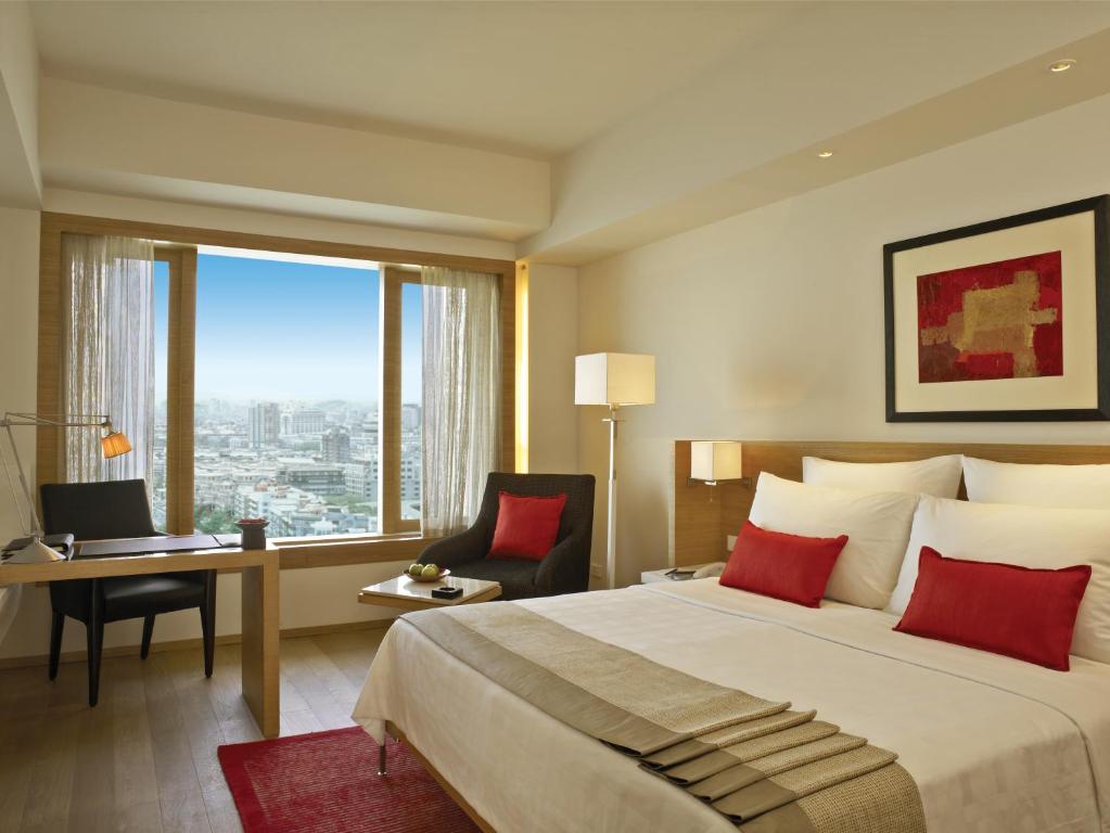 孟买纳瑞曼区三叉酒店 的配有一张床、一张书桌和一扇窗户的酒店客房