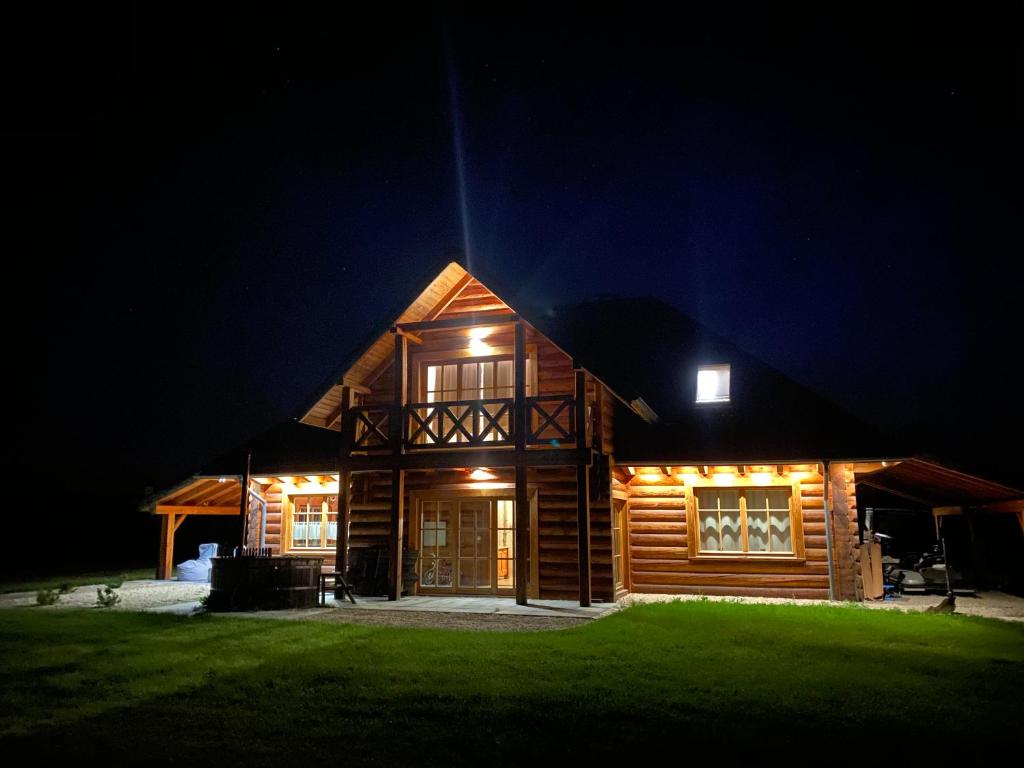 WolimierzWolimierz 80的夜间的小木屋,灯光照亮