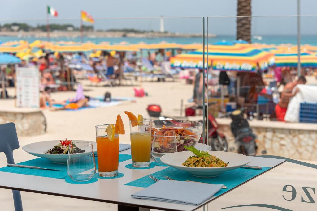 圣维托罗卡波里维埃拉酒店 的海滩上一张桌子,上面放着食物和饮料