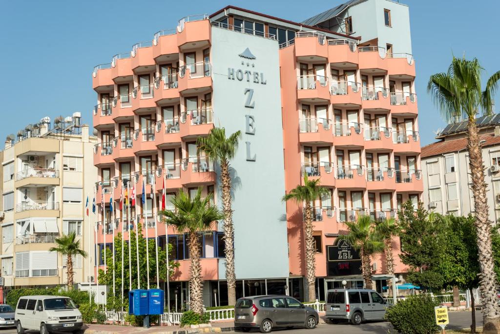 安塔利亚扎尔酒店的一座大型粉红色建筑,上面有标志