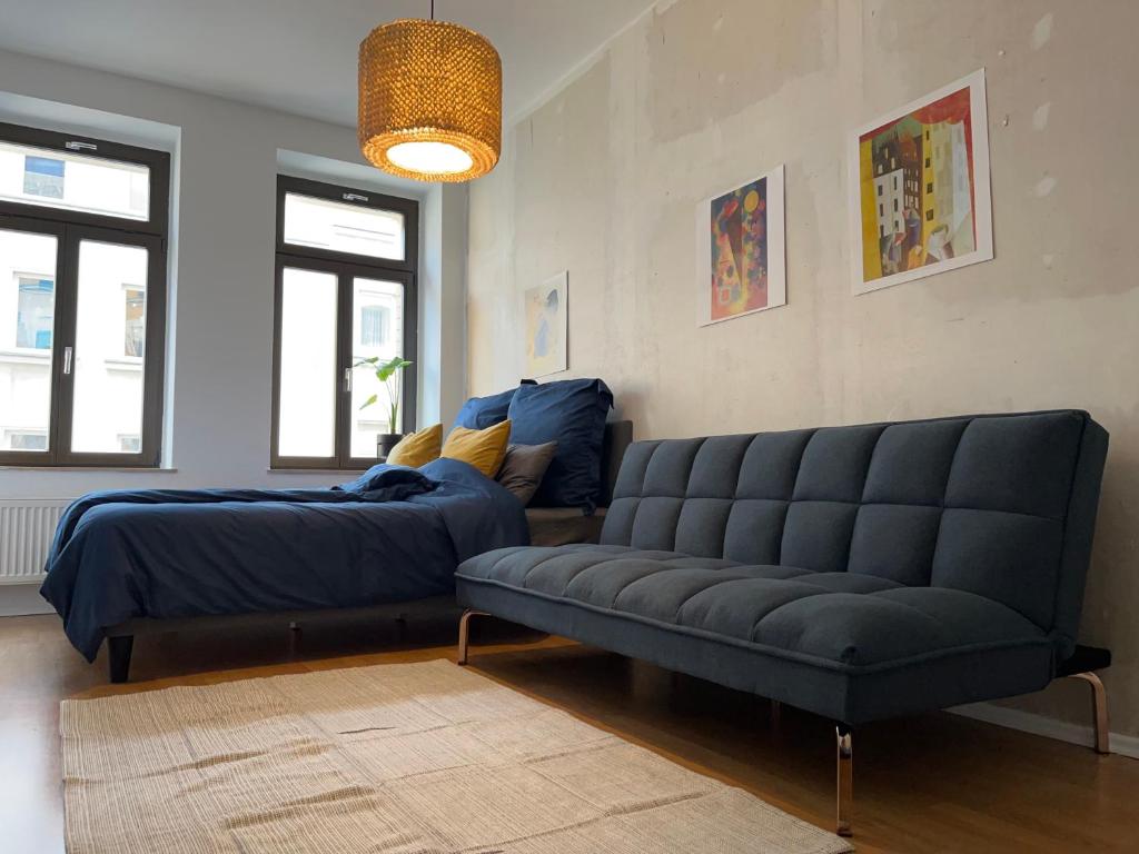 莱比锡Stilvoller Altbau mit Balkon - 10 min to center的客厅配有床和沙发