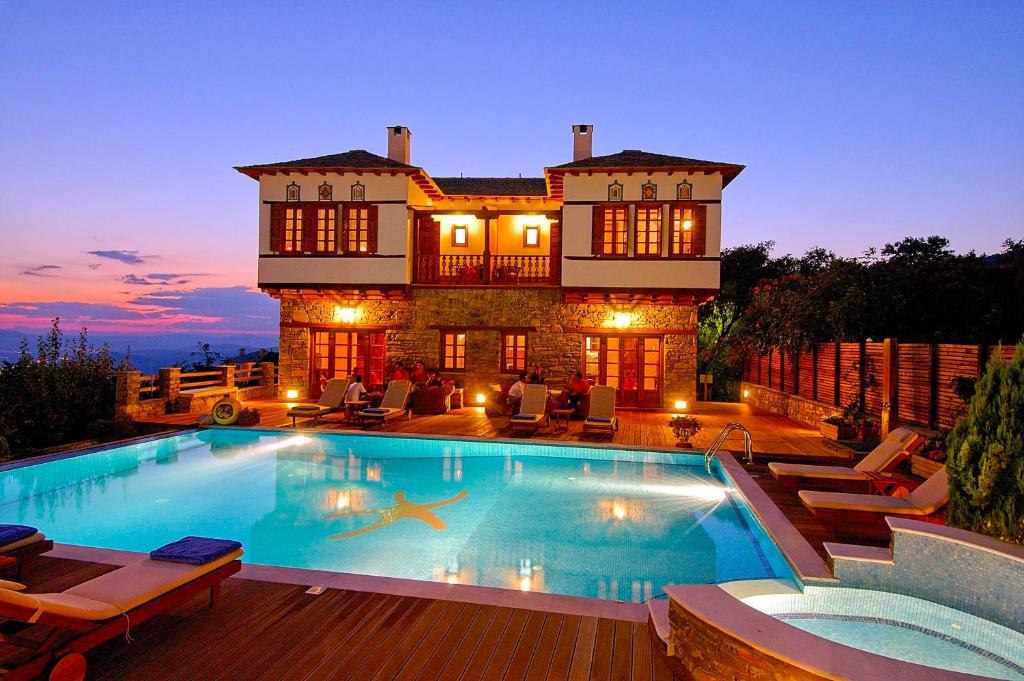 波尔塔里亚阿肯提克纳欧米迪酒店的一座大房子,前面设有一个游泳池