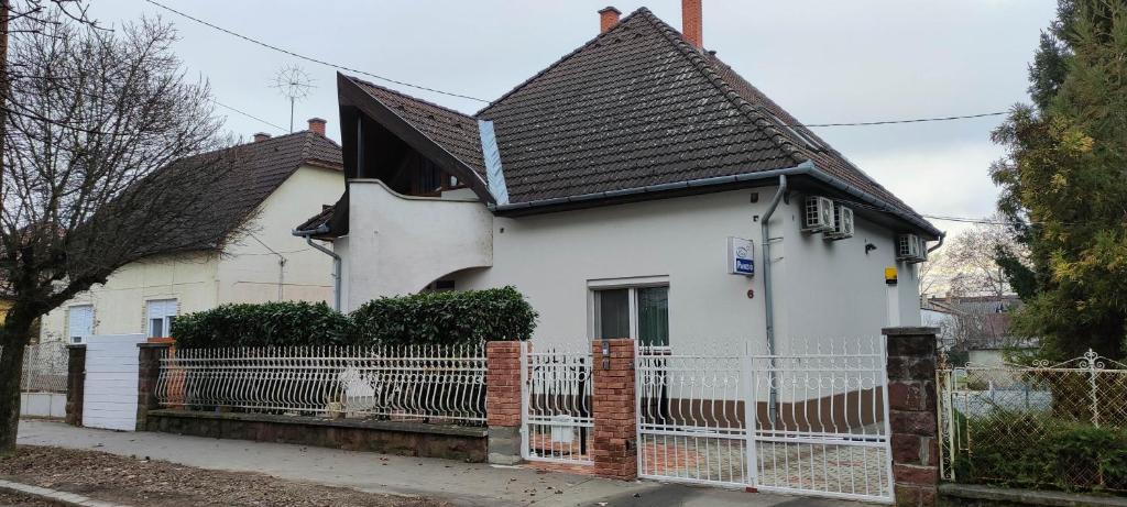 考波什堡Éva Vendégház的前面有栅栏的白色房子
