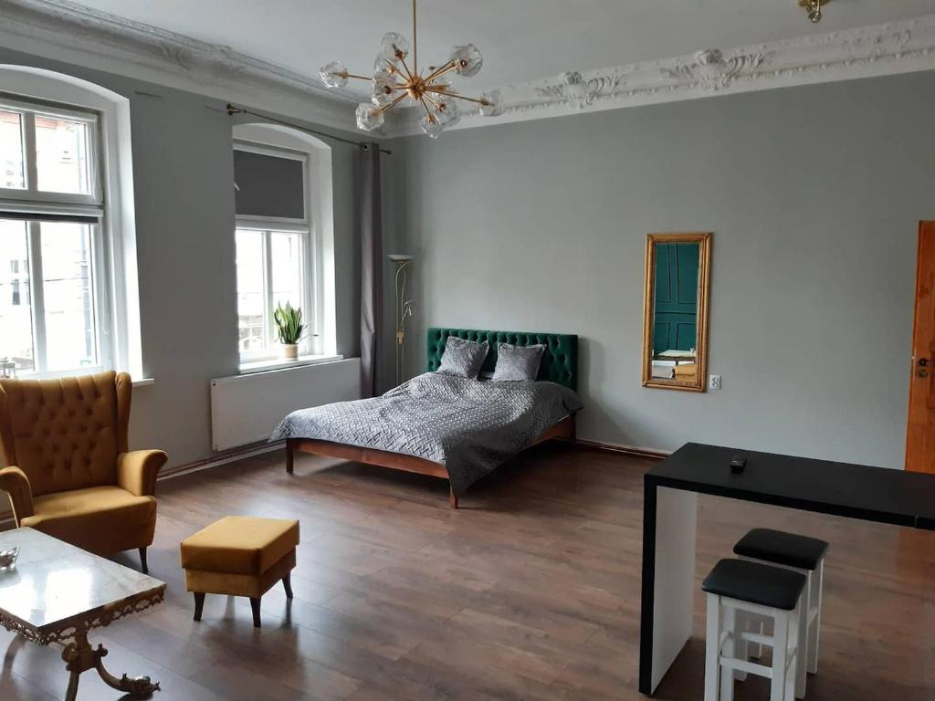 比得哥什Kamienica Bydgoska的一间卧室设有一张床和一间客厅。