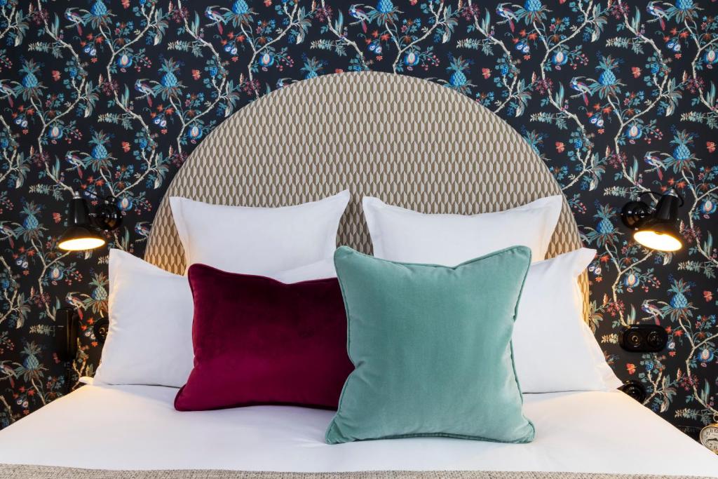 巴黎Hotel Fior d'Aliza的花卉墙前的一张带四个枕头的床
