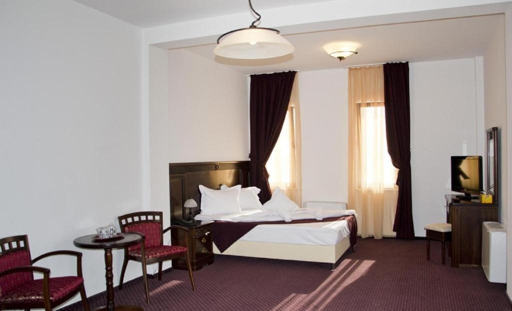 布拉索夫汉努尔多奈斯旅馆的酒店客房带一张床、一张桌子和椅子