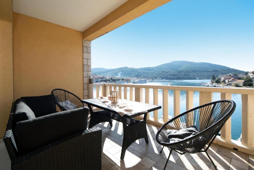 尼亚卢卡Apartments Dea Caeli的阳台配有桌椅,享有水景。